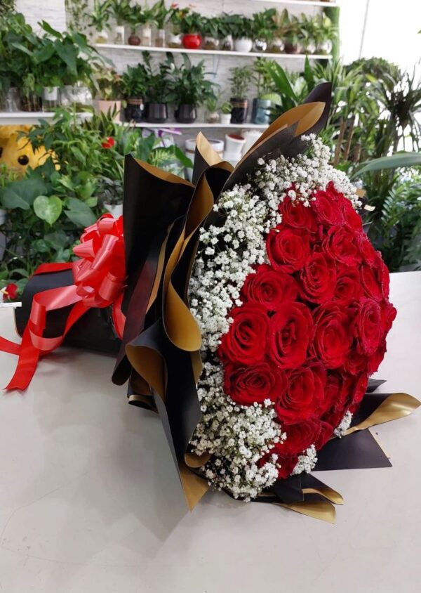 100 red rose bouquet with fresh vibrant roses, accented with baby's breath and wrapped in black and gold paper, perfect for romantic occasions and available for delivery in Dubai and Sharjah.