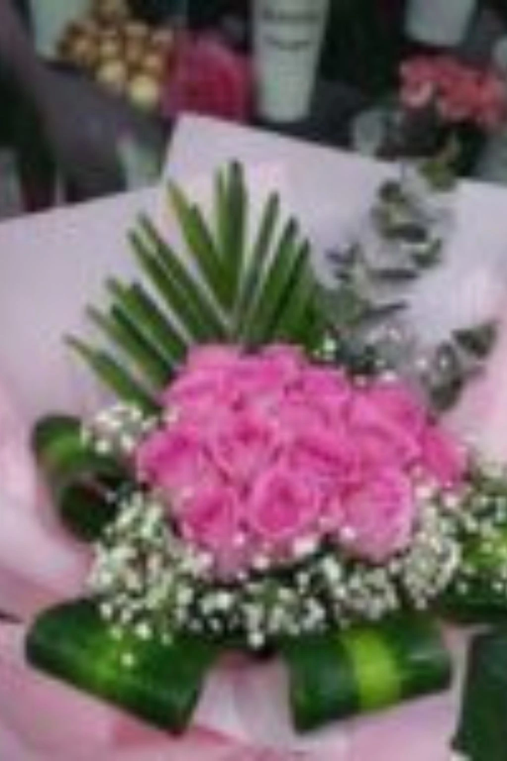Premium pink rose bouquet wrapped in soft pink paper with greenery, perfect for weddings and anniversaries