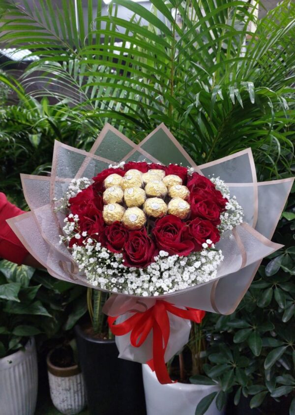 Luxurious Red Roses and Ferrero Rocher Bouquet with baby's breath, wrapped in premium floral paper and tied with a red ribbon.