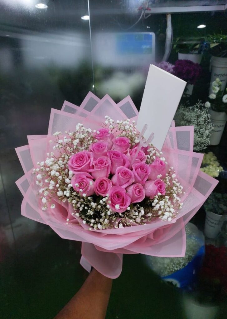 Graduation bouquet with roses and sunflowers wrapped in elegant paper, delivered in Sharjah near university area