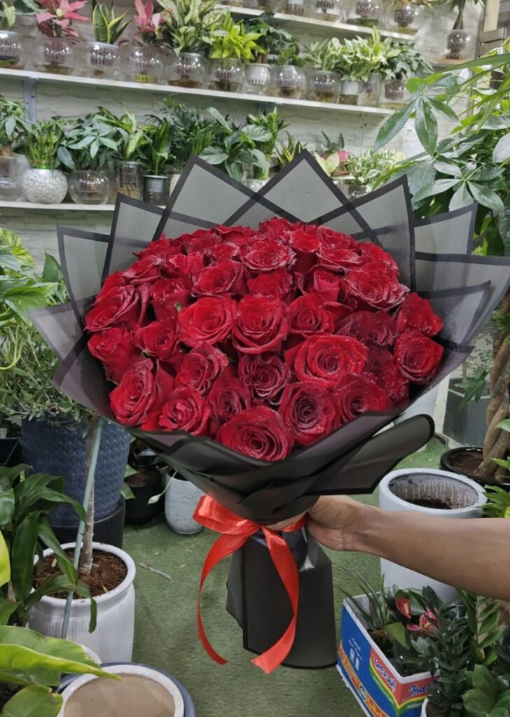 Luxury red roses bouquet with black wrapping and red ribbon, premium flower delivery in Sharjah and Ajman within 1 hour