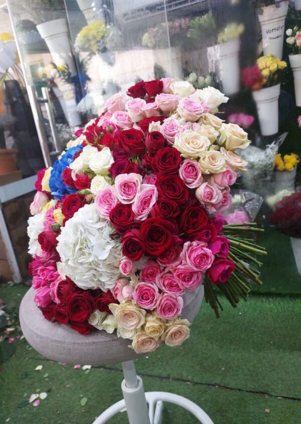 Luxury bouquet with 101 spray roses and 5 hydrangeas in red, pink, peach, white, and blue colors – perfect for weddings, events, and premium gifts in Dubai.