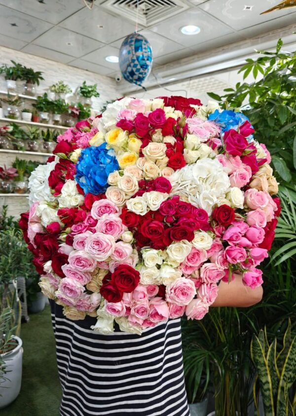 Luxury bouquet with 101 spray roses and 5 hydrangeas in red, pink, peach, white, and blue colors – perfect for weddings, events, and premium gifts in Dubai. Caption: