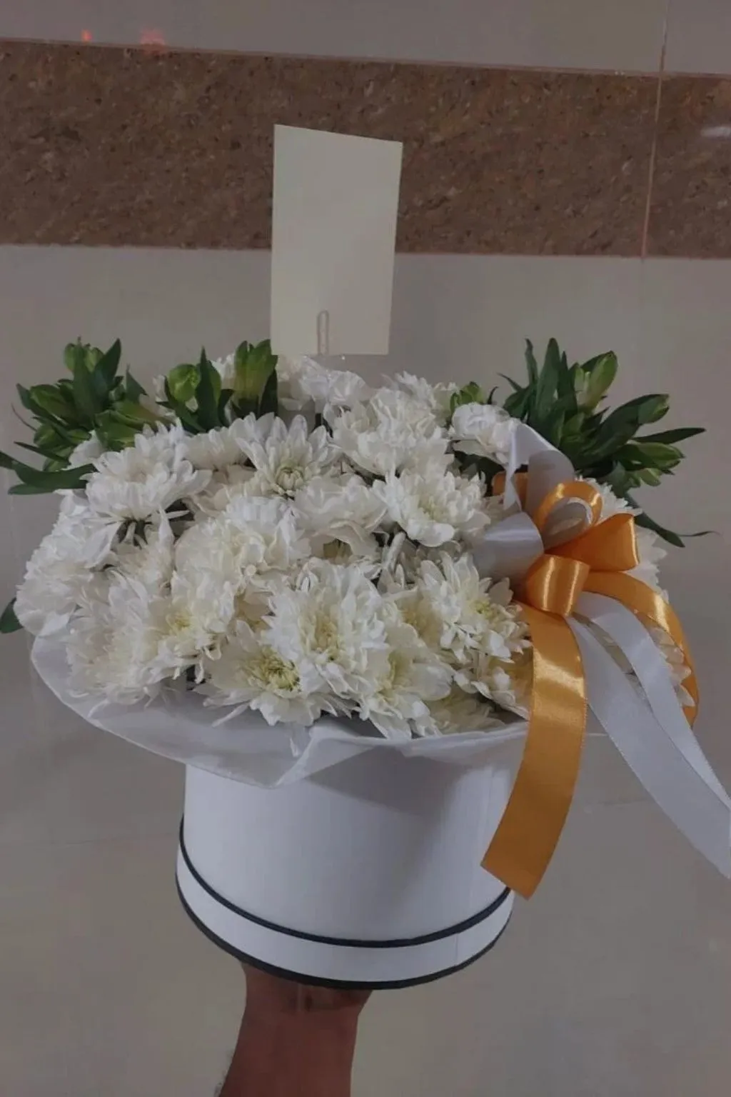 Close-up of fresh white chrysanthemum blooms in a gift hat box