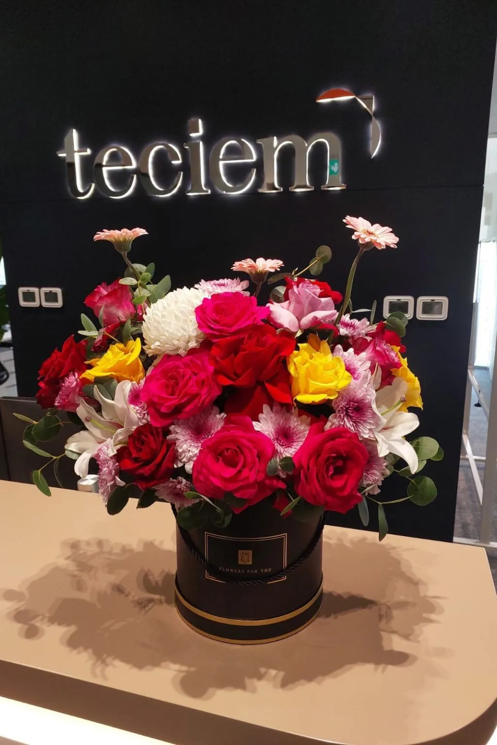 Vibrant mixed flower box in a black hat box with gold trim, ready for delivery in Dubai
