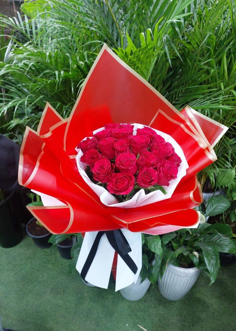 Elegant 21 red roses bouquet wrapped in premium red and gold paper, tied with a black ribbon, perfect for romantic occasions.