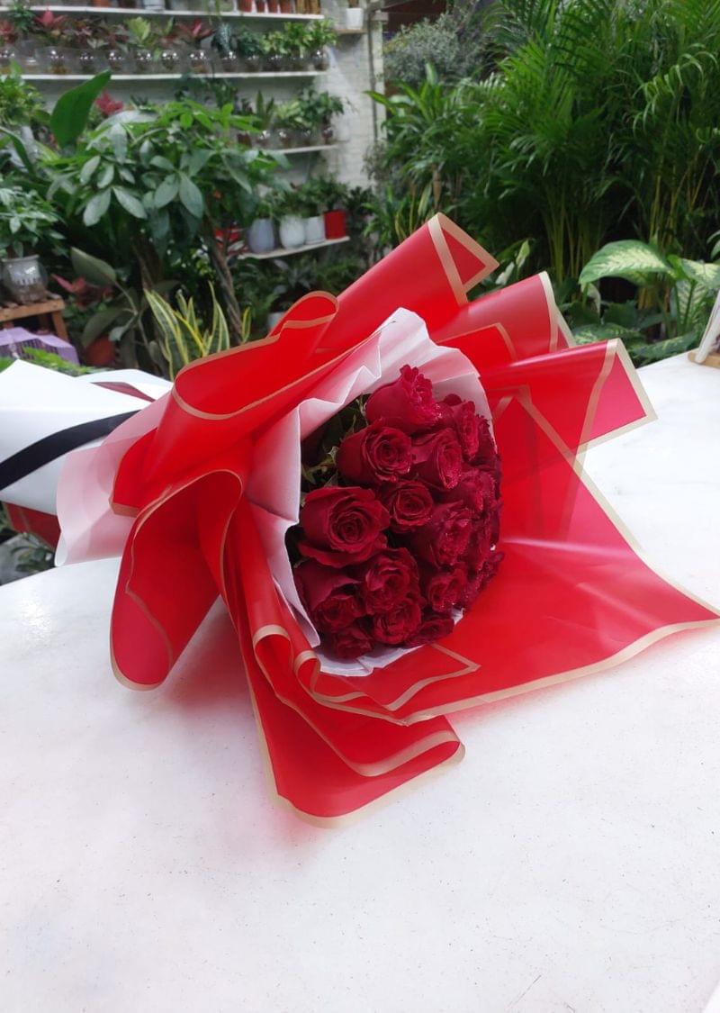 Elegant 21 red roses bouquet wrapped in premium red and gold paper, tied with a black ribbon, perfect for romantic occasions.