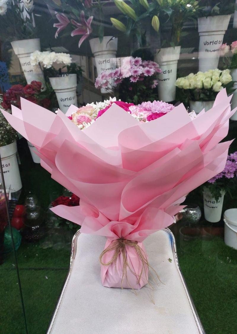 Premium Pink Bliss Bouquet featuring pink roses, white chrysanthemums, and baby’s breath in elegant pink wrapping.