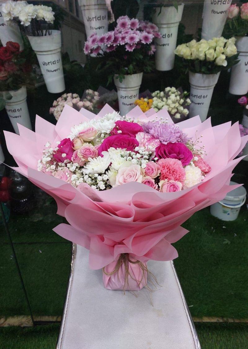 Premium Pink Bliss Bouquet featuring pink roses, white chrysanthemums, and baby’s breath in elegant pink wrapping.