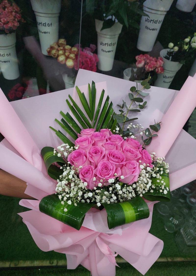 Premium pink rose bouquet wrapped in pink paper with greenery, perfect for special occasions and delivery in Dubai.