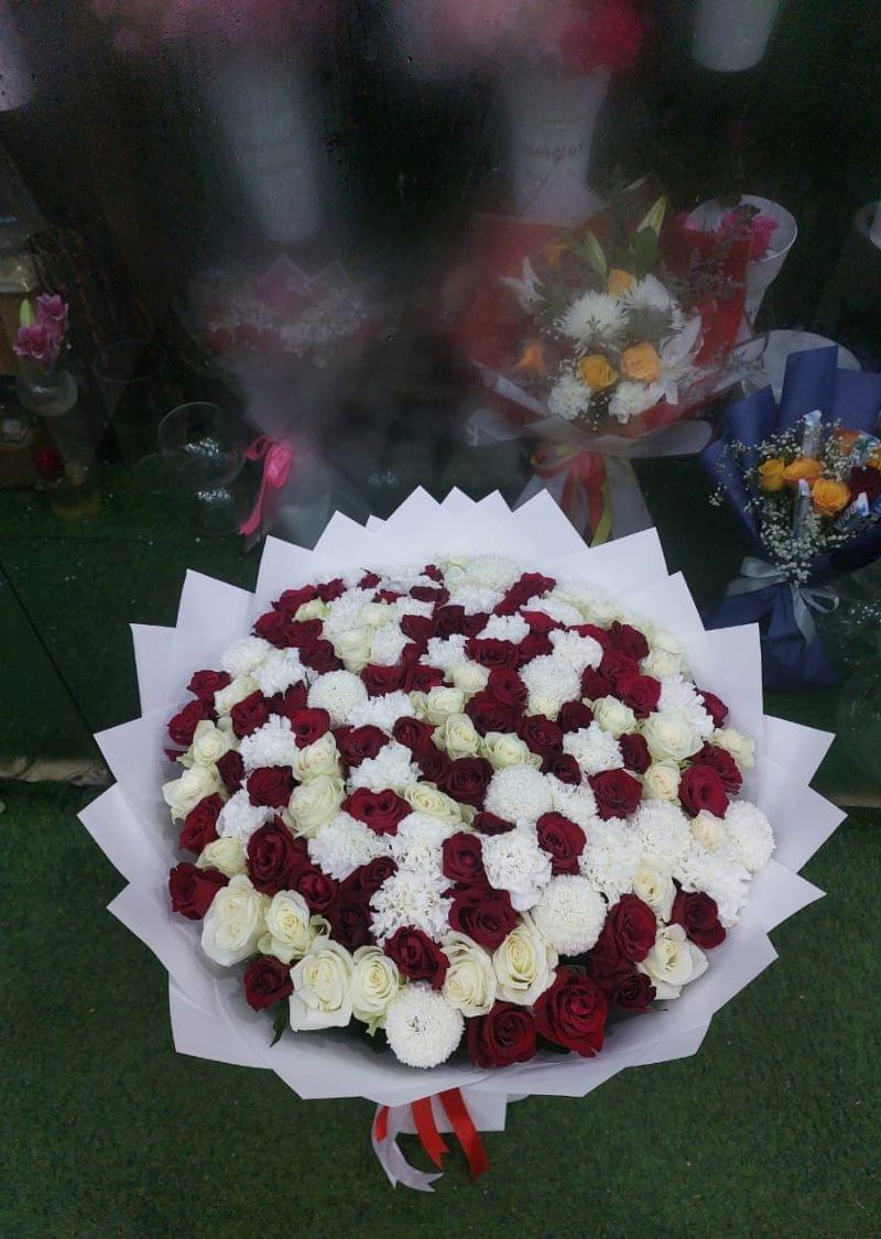 Elegant luxury bouquet with red and white roses and white chrysanthemums, beautifully wrapped with a red and white ribbon, perfect for gifting in Dubai.