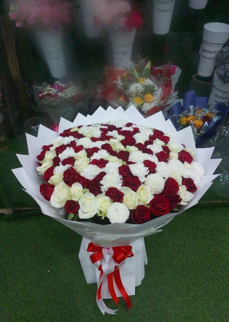Elegant luxury bouquet with red and white roses and white chrysanthemums, beautifully wrapped with a red and white ribbon, perfect for gifting in Dubai.