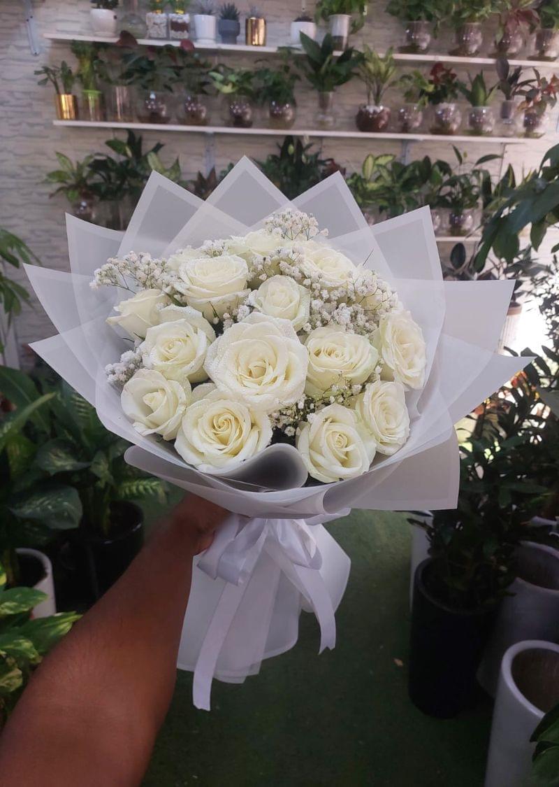 A beautifully arranged white roses bouquet wrapped in elegant white paper with delicate baby’s breath flowers, perfect for weddings, anniversaries, and special occasions.
