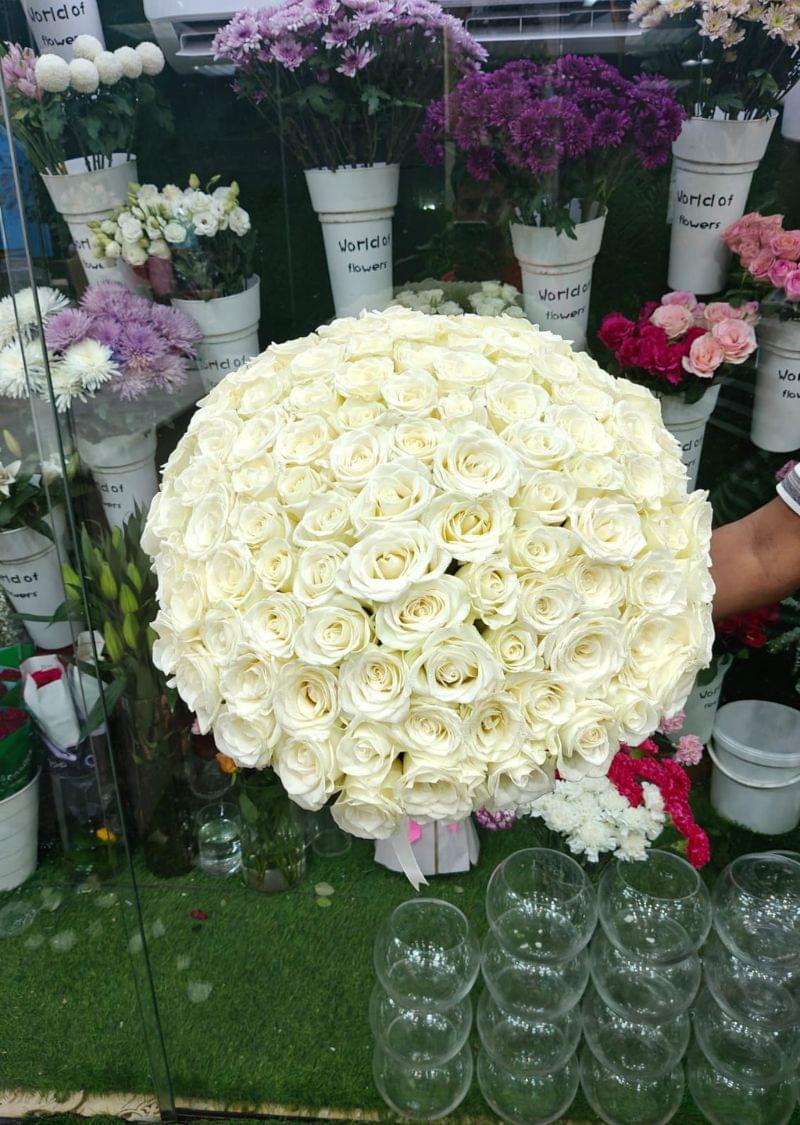 Hand-tied bouquet of 101 fresh white roses, elegantly arranged and wrapped with a satin ribbon, perfect for weddings, anniversaries, and romantic occasions in Dubai.