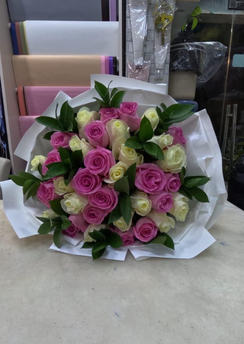 Pink and white rose bouquet with green leaves, wrapped in elegant white paper – perfect for gifting in Dubai.