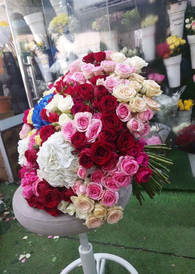 Luxury bouquet with 101 spray roses and 5 hydrangeas in red, pink, peach, white, and blue colors – perfect for weddings, events, and premium gifts in Dubai.
